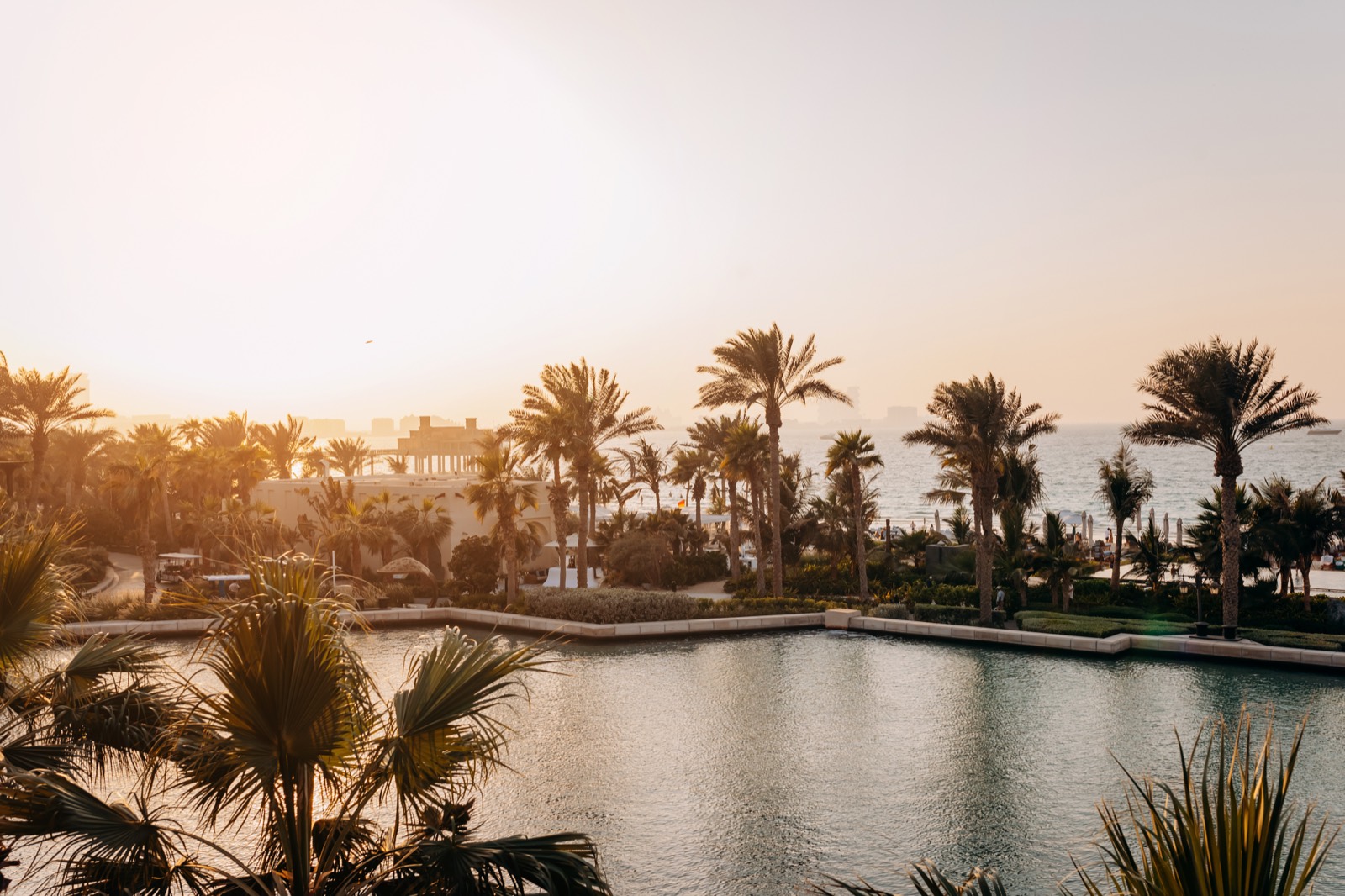 Luxury Dubai beach resort with palm trees and a waterway at sunset